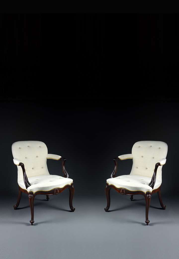 A fine pair of carved mahogany open armchairs
